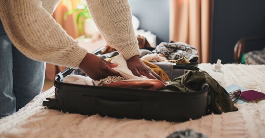 woman packing her things into a suitcase